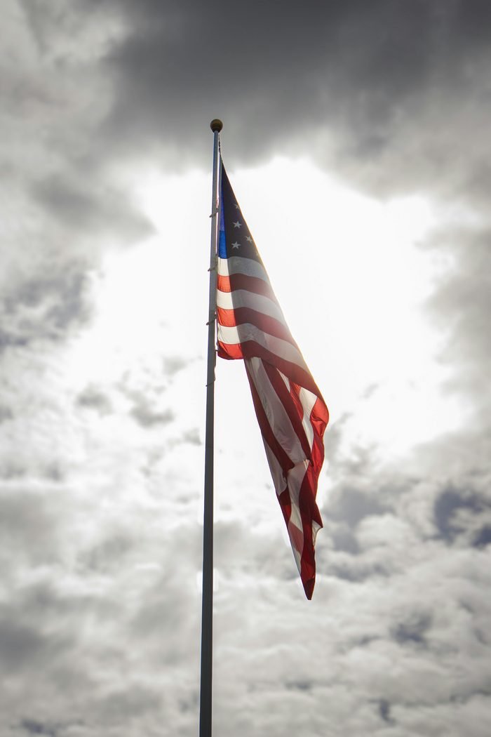 American flag waving against a dramatic cloudy sky